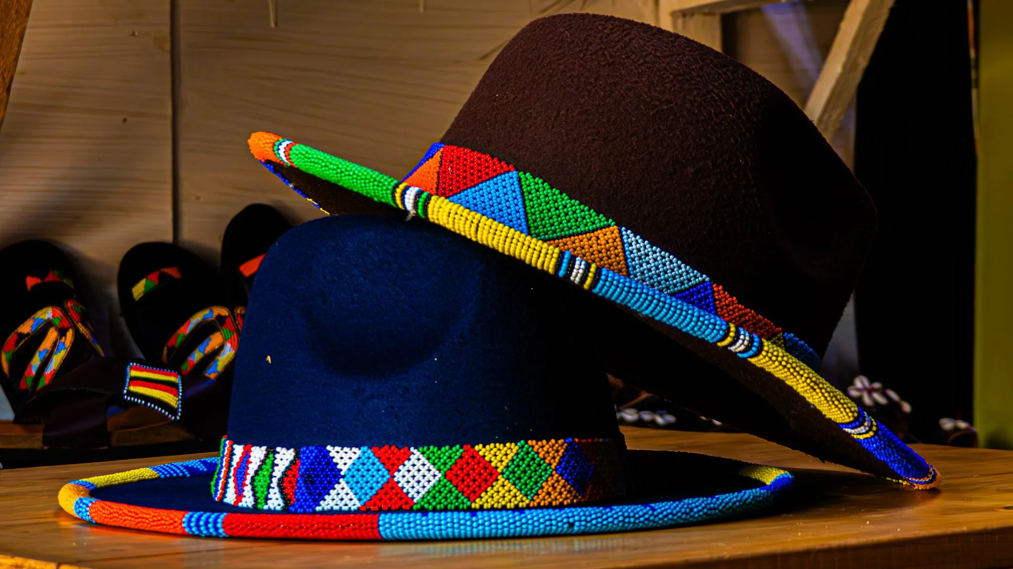 Photo: A medium, eye-level photograph of two felt fedora-style hats resting on a wooden surface.